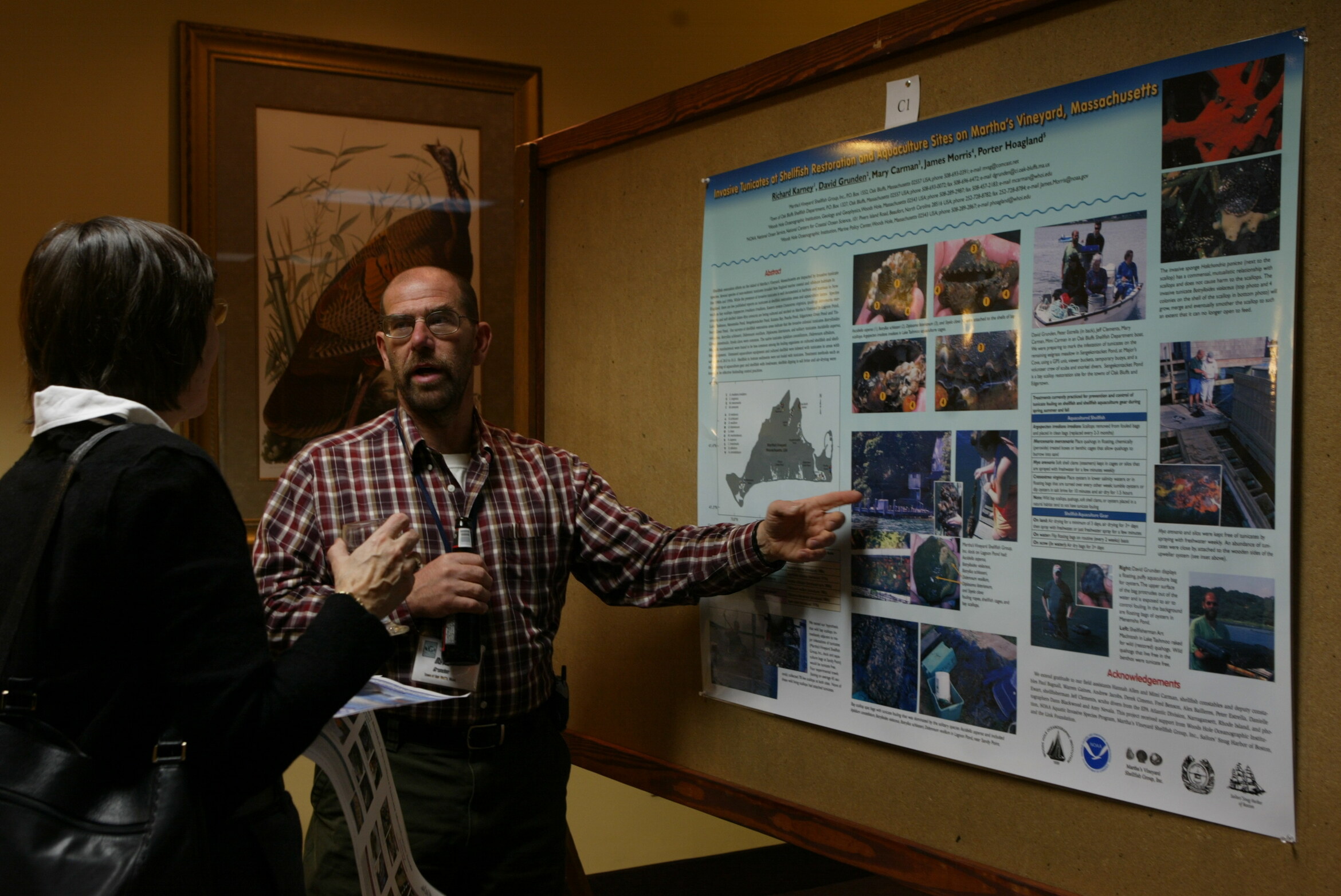 A presenter walking a delegate through a poster at an ICSR poster session