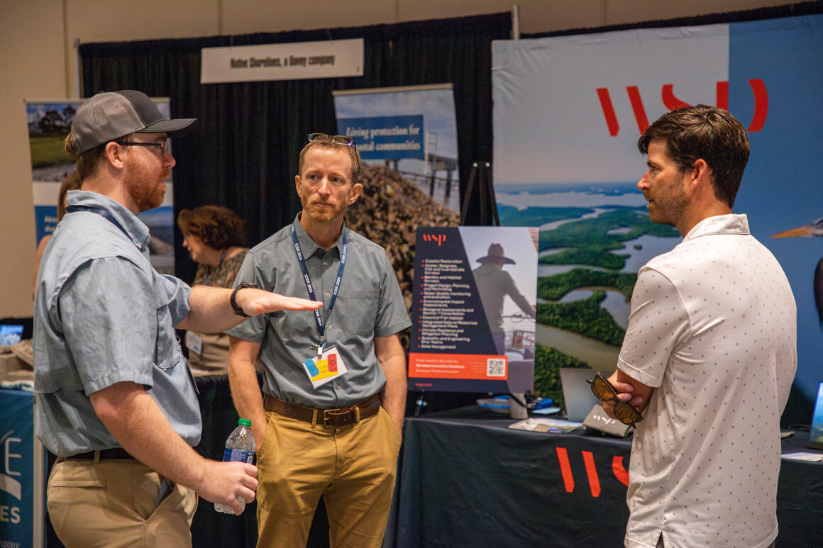 Delegates talking with an exhibitor at a booth in the exhibit hall